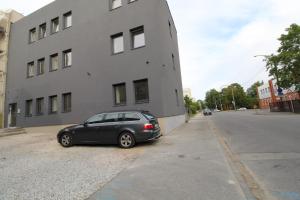 a car parked next to a building on a street at El Castillo Apartments in Tallinn