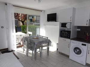 a kitchen with a table and a washing machine at Hameau des Thermes - appartement rez de chaussée in Saint-Lary-Soulan