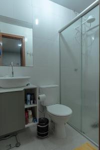 ein Bad mit einem WC und einer Glasdusche in der Unterkunft Apartamento Completo de 2 quartos em Gramado in Gramado