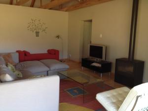 uma sala de estar com um sofá vermelho e uma televisão em Robertson Stays em Robertson