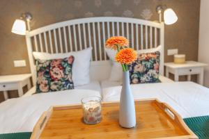 una mesa con un jarrón con flores en una cama en Kapitänshaus Sellin mit Sauna und Kamin, en Ostseebad Sellin