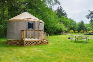 a yurt with a table and a picnic table in a field at Long beach Camping Resort Yurt 9 in Oceanview