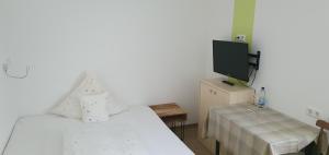um quarto com duas camas e uma televisão e uma mesa em Landgasthof/Hotel Hirsch im Grünen em Mehrstetten