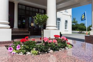 una exposición de flores frente a un edificio en Russ Hill Hotel en Charlwood