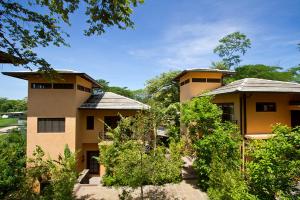 a couple of buildings with trees in front of them at Jet Luxury at Langosta Beach Resort & Villas in Tamarindo