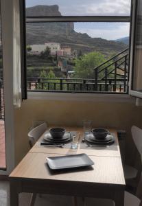 una mesa con vistas a la montaña desde una ventana en Un apartamento con vistas, aire acondicionado y wifi en Viguera