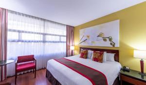 a hotel room with a large bed and a window at Hotel Palma Real in San José