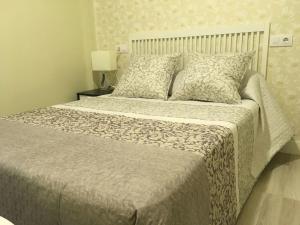 a bedroom with a large bed with a blanket and pillows at Centrico Apartament al lado de la estacion d tren Vivienda de uso Turistico in Logroño