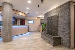 a stone wall in a lobby with a fireplace at Best Western Plus Sands in Vancouver