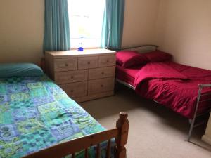 sypialnia z 2 łóżkami, komodą i oknem w obiekcie Beech Road w mieście Newport