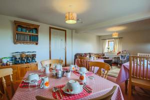 una sala da pranzo con tavolo e tovaglia rosa di Foxhill Fold a Gisburn