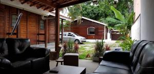 a living room with two leather couches and a car at Recanto dos Albatrozes in Boicucanga