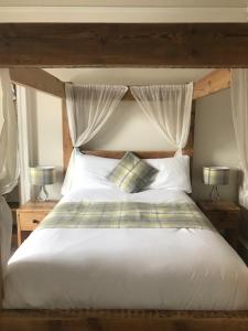 愛丁堡的住宿－克雷格米勒公園18號旅館，一间卧室配有一张带两盏灯的大型白色床。