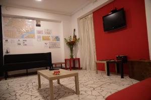 uma sala de estar com televisão numa parede vermelha em Hostel Calábria na Vila Madalena junto a alegria da Vila em São Paulo