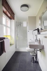 a bathroom with a toilet and a sink and a shower at Altes Pfarrhaus in Geldern