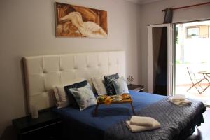 a bedroom with a bed with blue sheets and a painting at Doca do Cavacas Apartment in Funchal