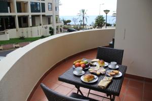 a table with plates of food on a balcony at Doca do Cavacas Apartment in Funchal