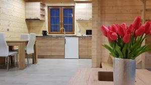 a vase of red tulips sitting on a table in a kitchen at DOMEK AGA in Kruklanki