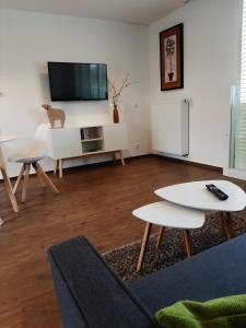 ein Wohnzimmer mit 2 Tischen und einem TV in der Unterkunft Gemütliche Ferienwohnung, Ländlich und Stadtnah, ruhig gelegen in Rheda-Wiedenbrück