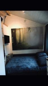 a room with a bed and a painting on the wall at Villa Lillgården with Sauna and Jacuzzi in Norrköping