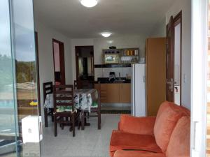 a living room with a couch and a table and a kitchen at Residencial Fran Chiattone in Natal