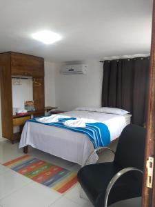 1 dormitorio con 1 cama y 1 silla en Residencial Fran Chiattone, en Natal