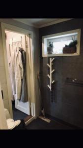 a bathroom with a door to a shower and a toilet at Villa Lillgården with Sauna and Jacuzzi in Norrköping