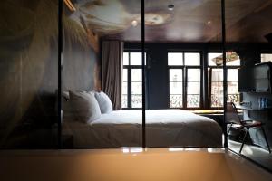 a bedroom with a bed and a large mirror at HotelO Kathedral in Antwerp