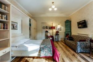 een slaapkamer met een bed en een bank bij Studios at Anchevskih 3 in Lviv