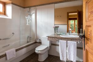 
a bathroom with a toilet, sink, and shower at Parador de Tui in Tui
