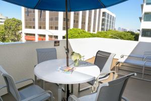 a dining room table with an umbrella over it at Gateway Hotel Santa Monica in Los Angeles