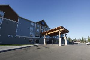 um grande edifício com um parque de estacionamento em frente em Pomeroy Inn & Suites at Olds College em Olds