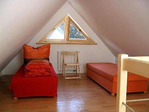 カルパチにあるDom w Karkonoszachのベッド2台と窓が備わる屋根裏部屋です。