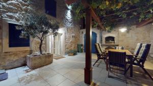 a dining room with a table and chairs in a stone building at Villa Lantina in Betina