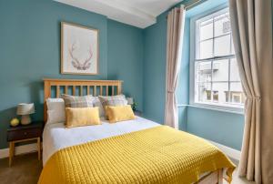 a blue bedroom with a bed and a window at Rose Apartment in Edinburgh