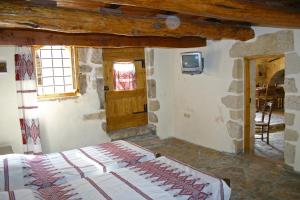 a bedroom with a bed and a window and a tv at Vafes Traditional Stone Houses in Vafés
