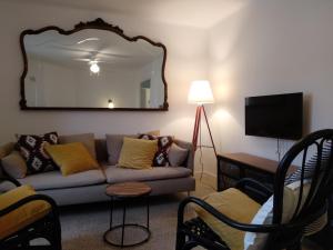 a living room with a couch and a mirror at Cal Genís de Montmajor - WIFI in Montmajor