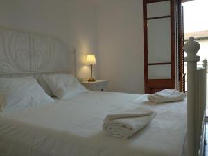 a white bed with two towels on top of it at Cal Genís de Montmajor - WIFI in Montmajor