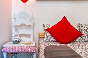 una camera con letto, cuscino rosso e sedia di Casa Coco a Lecce