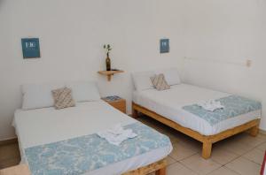 a room with two beds in a room at Las Palmas in Zihuatanejo