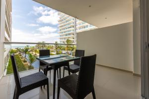 balcón con mesa y sillas y ventana grande en Morros Epic 216, en Cartagena de Indias