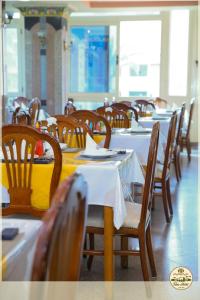 uma sala de jantar com mesas e cadeiras com toalhas de mesa brancas em Teba Hotel Ras Elbar em Ras El Bar