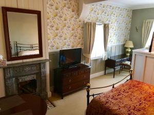 a bedroom with a fireplace and a television and a mirror at Durham Ox Ilkeston in Derby