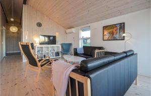 een woonkamer met een zwarte leren bank en stoelen bij Lovely Home In Vinderup With Wifi in Vinderup