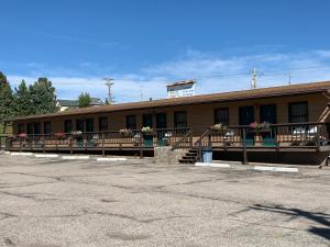 a building with benches and flowers in front of it at Chief Motel in Custer