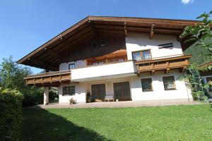 a large white house with a wooden roof at Ferienwohnungen Christine in Waidring