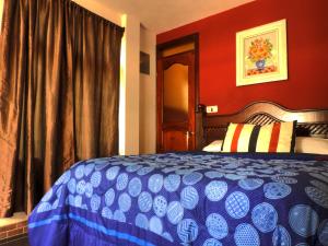 a bedroom with a blue bed and red walls at SHANTI SHANTI Hotel & Restaurante in San Pedro La Laguna