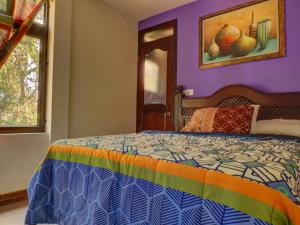 1 dormitorio con 1 cama con colcha colorida en SHANTI SHANTI Hotel & Restaurante, en San Pedro La Laguna