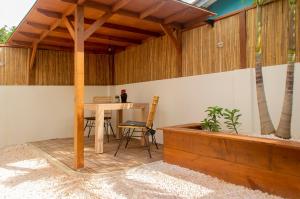eine Terrasse mit einem Tisch und einem Holzdach in der Unterkunft Kas Despacito in Kralendijk
