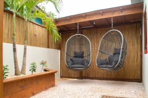 two wicker chairs hanging on a fence with palm trees at Kas Despacito in Kralendijk